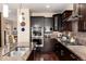 Gourmet kitchen with dark cabinetry, stainless steel appliances, granite counters, hardwood floors and open design at 2042 S Clayton St, Denver, CO 80210
