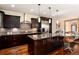 Gourmet kitchen with dark cabinetry, stainless steel appliances, a center island with bar seating, and hardwood floors at 2042 S Clayton St, Denver, CO 80210