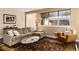 Comfortable living room featuring neutral tones, large windows, a plush sofa, and stylish decor for relaxed living at 2042 S Clayton St, Denver, CO 80210