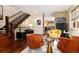 Open-concept living room features hardwood floors, staircase, designer furniture, and a peek into the dining area at 2042 S Clayton St, Denver, CO 80210