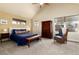 Cozy main bedroom with vaulted ceiling, comfortable bed, reading chair, and ample natural light from large windows at 2042 S Clayton St, Denver, CO 80210