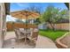 Landscaped backyard with a dining set, shade umbrella, lush green lawn, and a storage shed at 9790 E 5Th Ave, Aurora, CO 80010