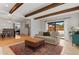 Inviting living room featuring a large rug, wood beams, and sliding glass doors to the backyard at 9790 E 5Th Ave, Aurora, CO 80010