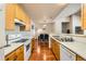 Open kitchen design with oak cabinets and hardwood floors seamlessly connects to the dining area at 14221 E 1St Dr # 303, Aurora, CO 80011