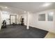 Spacious basement featuring a black rubber floor and home gym equipment, perfect for workouts at 3504 Newton St, Denver, CO 80211