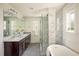 Bright bathroom featuring marble countertops, a soaking tub, and a glass-enclosed shower at 3504 Newton St, Denver, CO 80211