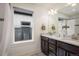 Bathroom with a dual sink vanity, marble countertops, and modern fixtures at 3504 Newton St, Denver, CO 80211