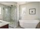 Bathroom featuring a soaking tub, glass-enclosed shower and marble countertops at 3504 Newton St, Denver, CO 80211