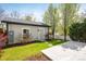 A detached garage features a concrete patio and green lawn with trees, perfect for outdoor activities at 3504 Newton St, Denver, CO 80211