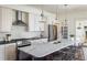 Open kitchen with marble island, stainless steel appliances, white cabinets, and bar stool seating at 3504 Newton St, Denver, CO 80211