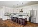 Bright kitchen with white cabinets, stainless steel appliances, and a large marble island with seating at 3504 Newton St, Denver, CO 80211