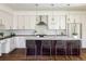 Modern kitchen with stainless steel appliances, island seating, and sleek countertops at 3504 Newton St, Denver, CO 80211