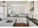 White kitchen featuring stainless steel appliances, marble countertops, and modern pendant lighting at 3504 Newton St, Denver, CO 80211