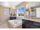 Modern bathroom with a separate shower, tub, double sinks, and large windows with neighborhood views at 20855 Park Hollow Dr, Parker, CO 80138