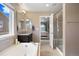 Bright ensuite bathroom featuring a separate shower, tub, and views into main bedroom at 20855 Park Hollow Dr, Parker, CO 80138