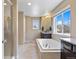 Bright, modern bathroom with a tub, separate shower, and windows offering natural light and views at 20855 Park Hollow Dr, Parker, CO 80138