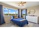 Charming bedroom with a blue bed set, ceiling fan, large window with scenic views, and natural light at 20855 Park Hollow Dr, Parker, CO 80138