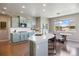 Well-lit kitchen features an island with seating, modern appliances, and an adjacent dining area at 20855 Park Hollow Dr, Parker, CO 80138
