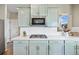 Close-up of a modern kitchen featuring a gas range, light blue cabinets, and subway tile backsplash at 20855 Park Hollow Dr, Parker, CO 80138