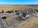 Aerial view of farm property with fencing in the foreground, farm land and fields in background at 724 County Road 37, Brighton, CO 80603