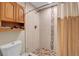 Full bathroom with tiled shower and stone floor and cabinet storage at 724 County Road 37, Brighton, CO 80603