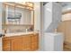 Well-lit bathroom featuring granite countertop, wood cabinets, and stackable washer and dryer at 724 County Road 37, Brighton, CO 80603