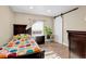 Cozy bedroom with colorful bedding, wood floors, and a sliding barn door for closet access at 724 County Road 37, Brighton, CO 80603