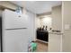 A mini kitchen with white refrigerator, dark cabinets, and a sink at 724 County Road 37, Brighton, CO 80603