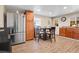 Bright kitchen with stainless steel refrigerator, wooden cabinets, and granite countertops at 724 County Road 37, Brighton, CO 80603