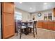 Eat-in kitchen features wooden cabinets, granite counters, and a round dining table at 724 County Road 37, Brighton, CO 80603