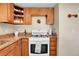 Kitchen with granite countertops, wooden cabinets, and a white gas range at 724 County Road 37, Brighton, CO 80603