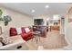 Cozy living room featuring a red sofa, entertainment center, and archway to the kitchen at 724 County Road 37, Brighton, CO 80603