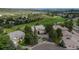 Stunning aerial view of a luxurious home on a lush golf course with mature trees and a circular driveway at 171 October Pl, Castle Rock, CO 80104