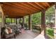 Inviting covered patio with stone pillars and wood ceiling with comfortable seating and access to the landscaped backyard at 171 October Pl, Castle Rock, CO 80104