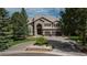 Stately stone and stucco home with circular driveway and mature landscaping at 171 October Pl, Castle Rock, CO 80104