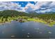 Picturesque aerial view of a lake surrounded by lush forest and mountains, featuring recreational boats at 4805 S Blue Spruce Rd, Evergreen, CO 80439