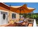 Outdoor living on the back deck with a grill, dining table, and shade from a large patio umbrella at 4805 S Blue Spruce Rd, Evergreen, CO 80439