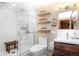 Modern bathroom with a glass-enclosed shower, wood vanity, floating shelves, and modern fixtures at 4805 S Blue Spruce Rd, Evergreen, CO 80439