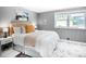 Well-lit bedroom featuring a queen bed, modern accents, a mountain scene, and a bright window at 4805 S Blue Spruce Rd, Evergreen, CO 80439