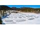 Aerial view of an outdoor ice skating area surrounded by forest and mountains at 4805 S Blue Spruce Rd, Evergreen, CO 80439