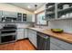 Modern kitchen with updated appliances, subway tile backsplash, wood countertops, and hardwood floors at 4805 S Blue Spruce Rd, Evergreen, CO 80439