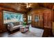 Beautiful living room with wood walls, a ceiling fan, a large window, and dark wood floors at 4805 S Blue Spruce Rd, Evergreen, CO 80439