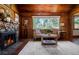 Inviting living room featuring a stone fireplace, hardwood floors, and a large window with natural light at 4805 S Blue Spruce Rd, Evergreen, CO 80439