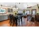 Open-concept area featuring dining table, living room seating and staircase with natural light from large windows at 4805 S Blue Spruce Rd, Evergreen, CO 80439
