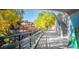 Charming walkway along a river, surrounded by trees and a building with colorful umbrellas at 4805 S Blue Spruce Rd, Evergreen, CO 80439