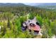 Beautiful home surrounded by a lush forest and features a rustic exterior and mountain views in the distance at 805 Highfield Trl, Breckenridge, CO 80424