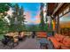 Scenic deck area with an outdoor fireplace, ample seating, and views of the mountains at 805 Highfield Trl, Breckenridge, CO 80424