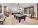 Spacious game room featuring a pool table, natural lighting, and access to another living area at 805 Highfield Trl, Breckenridge, CO 80424