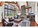 Spacious living room boasts exposed beams, stone fireplace, and picturesque windows framing the breathtaking mountain views at 805 Highfield Trl, Breckenridge, CO 80424