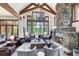 Inviting living room features vaulted ceilings, exposed beams, stone fireplace, and large windows with scenic views at 805 Highfield Trl, Breckenridge, CO 80424